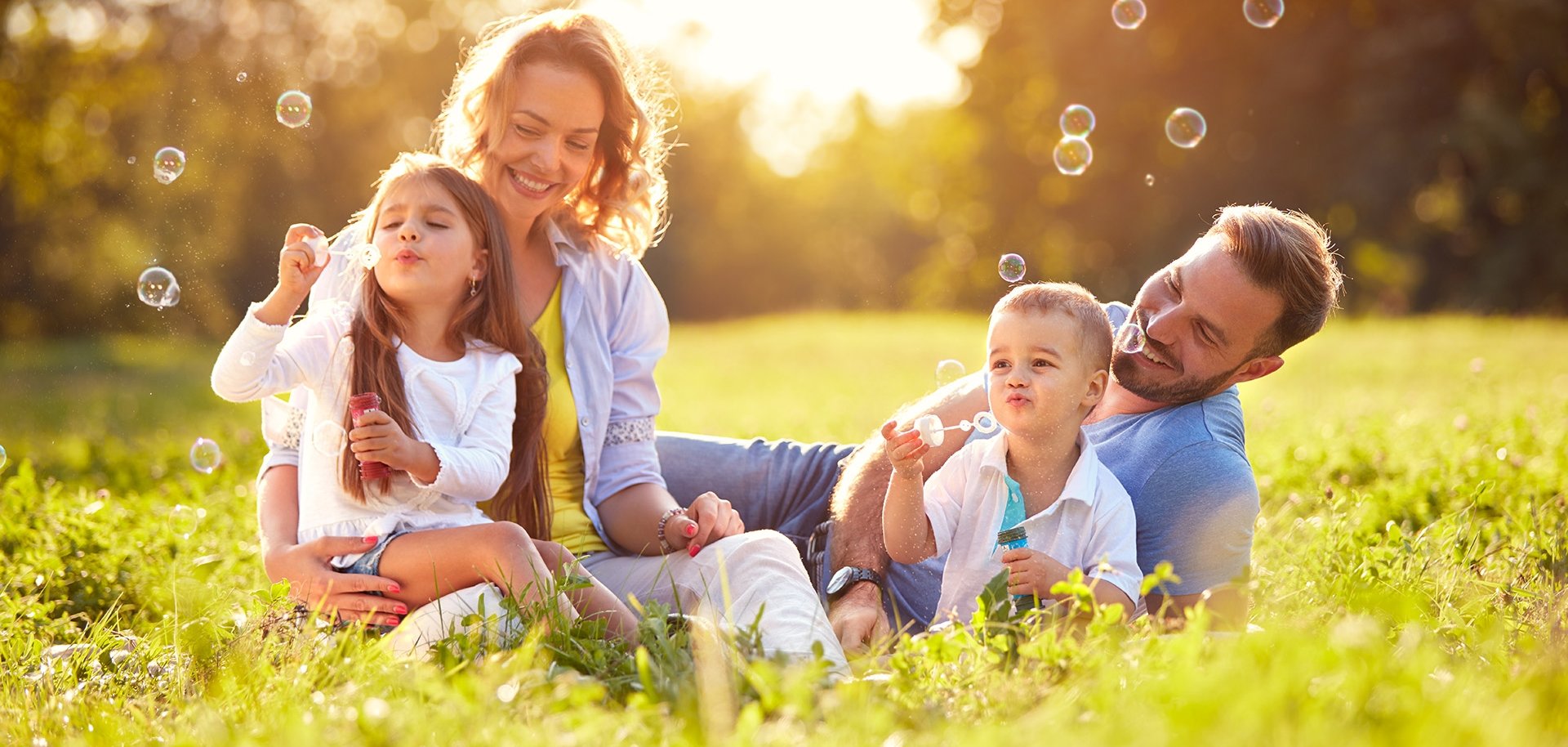 Male and female child blow soap bubbles