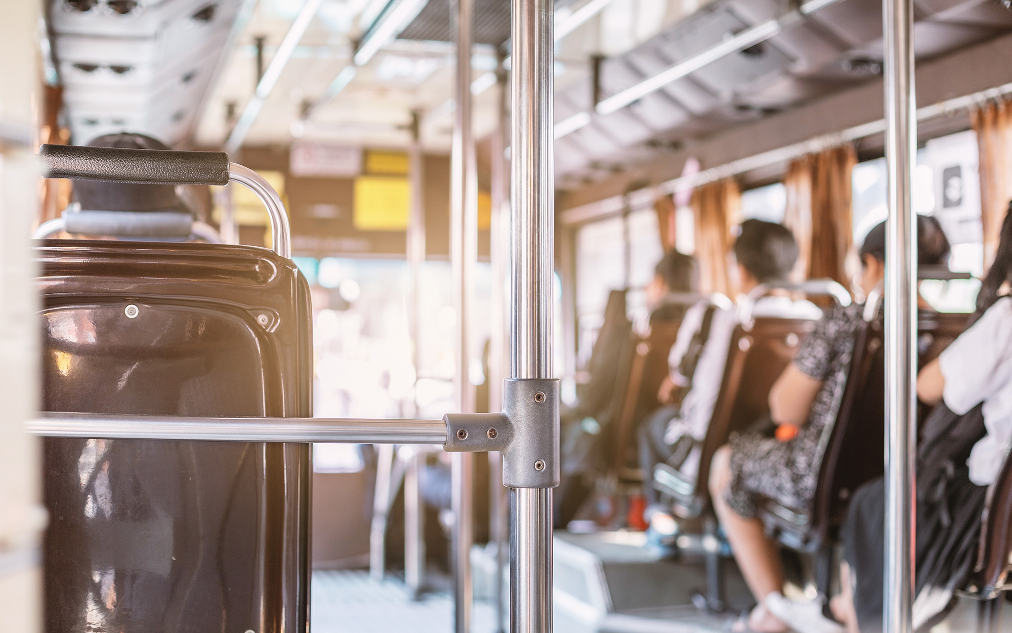 People sitting on seat in back view on the bus