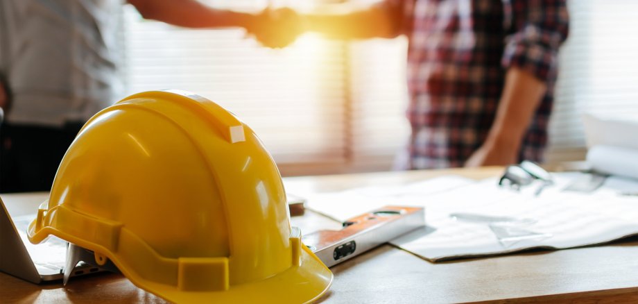 yellow safety helmet on workplace desk with construction worker yellow safety helmet on workplace desk with construction worker