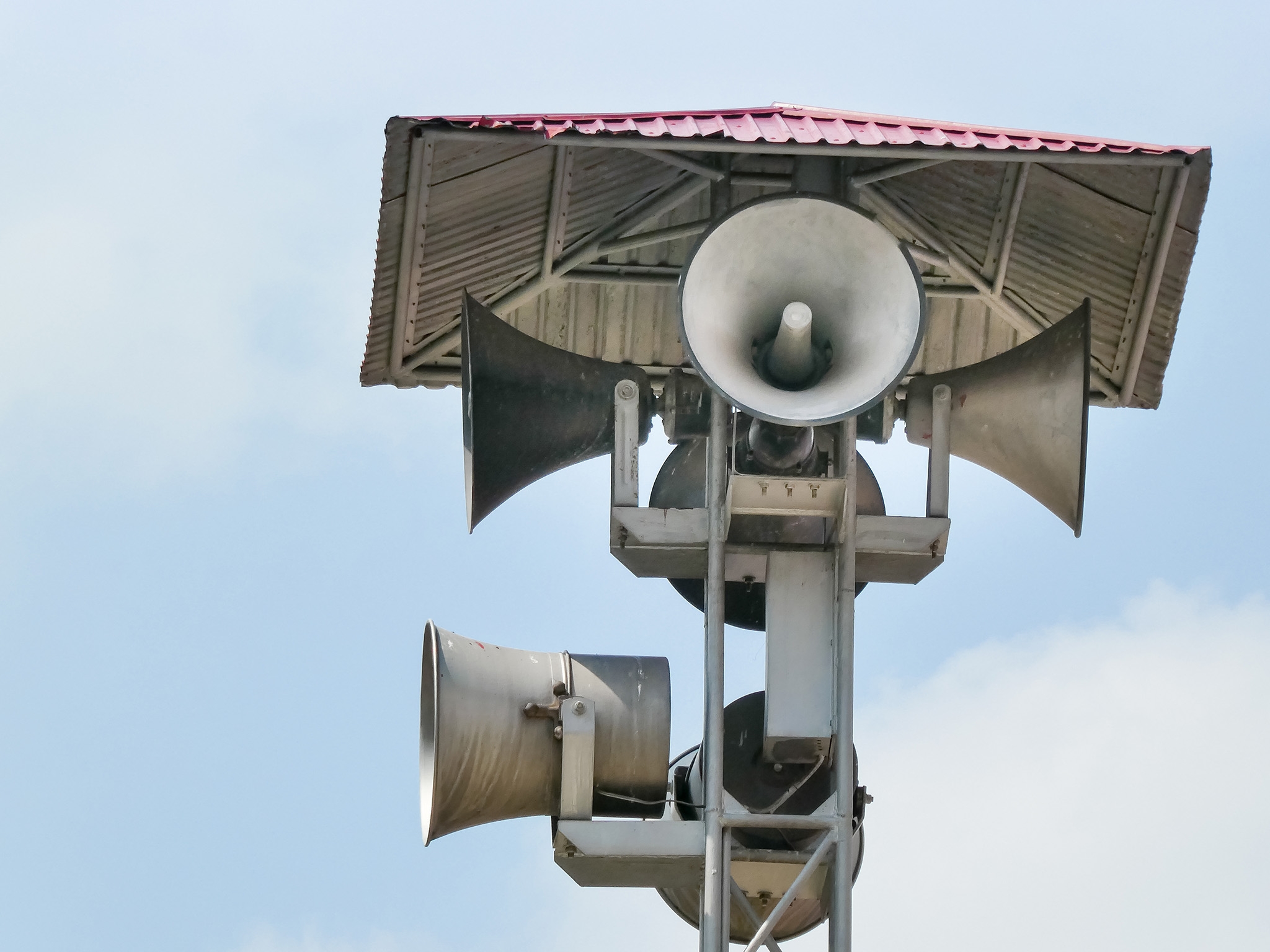 Vintage horn speaker tower with loudspeaker against the sky. Sys