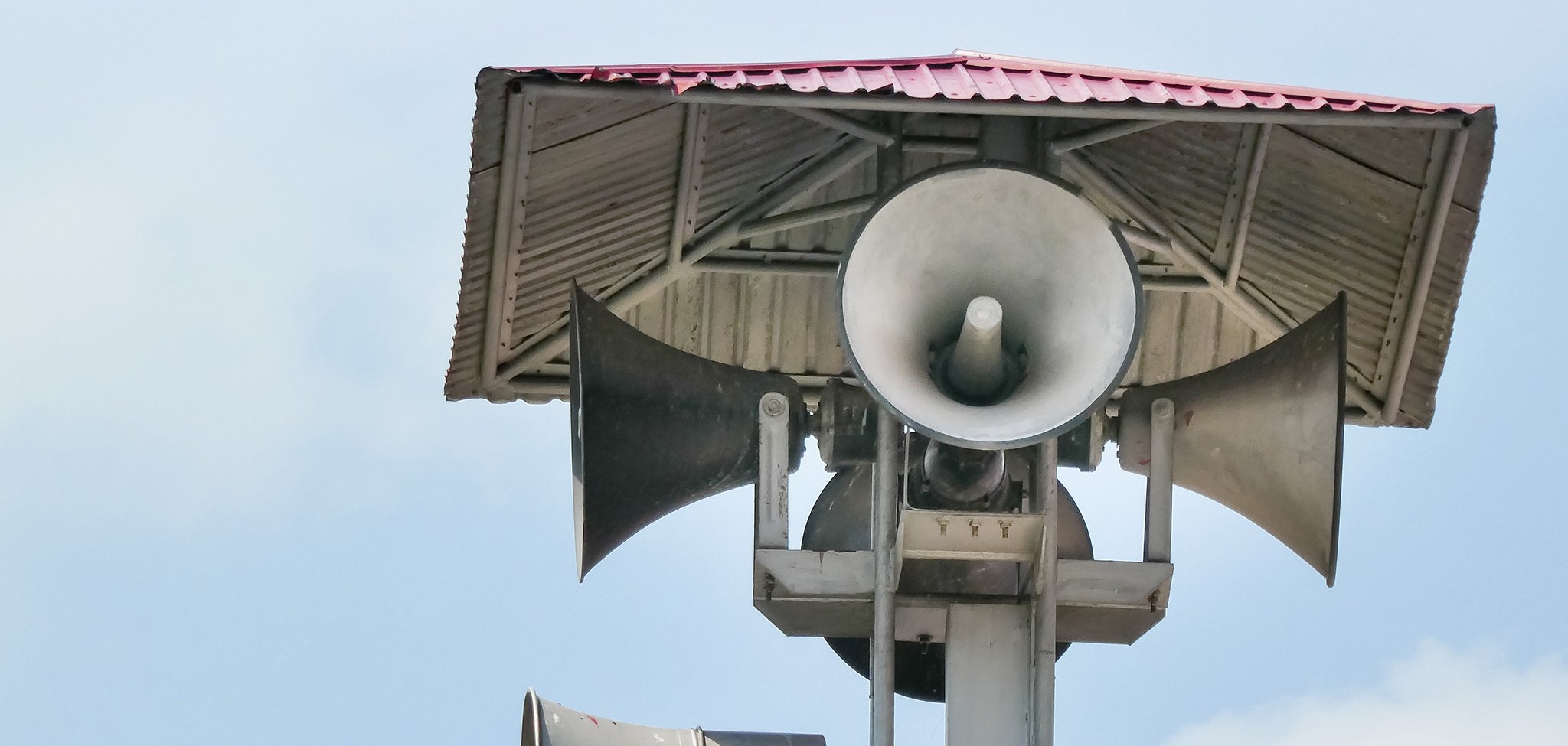 Vintage horn speaker tower with loudspeaker against the sky. Sys