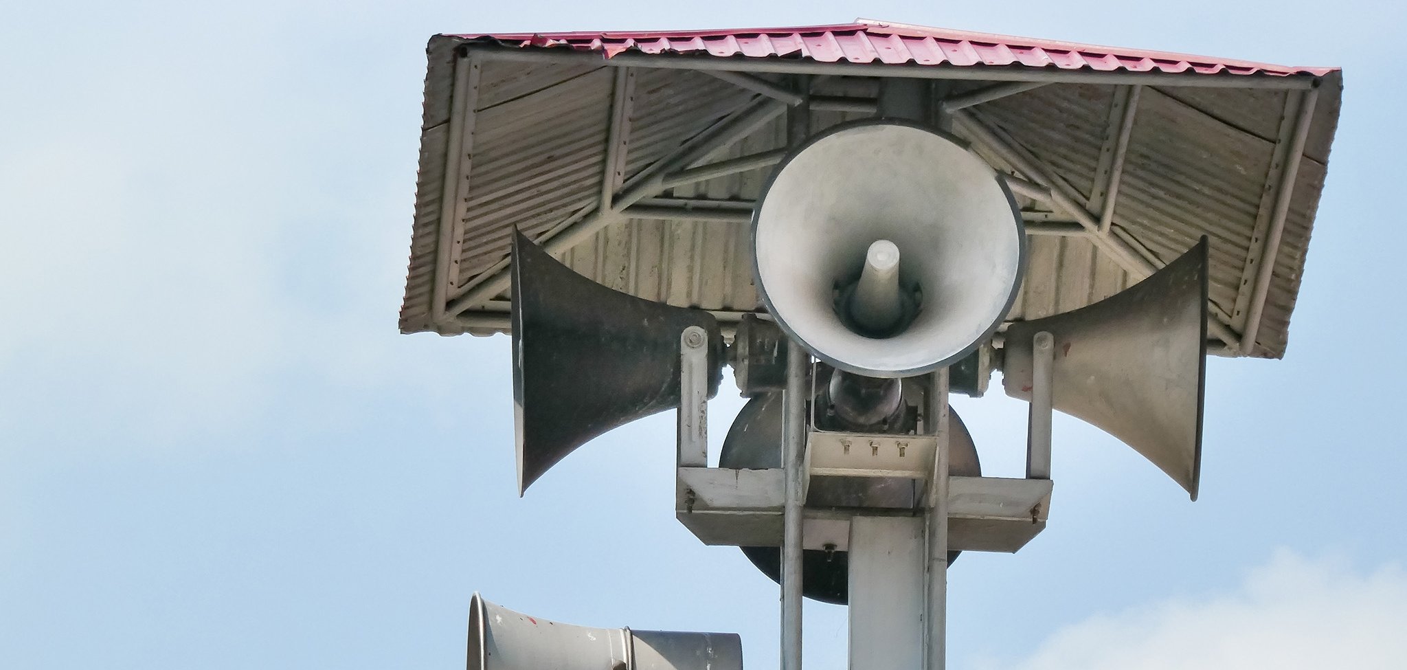 Vintage horn speaker tower with loudspeaker against the sky. Sys
