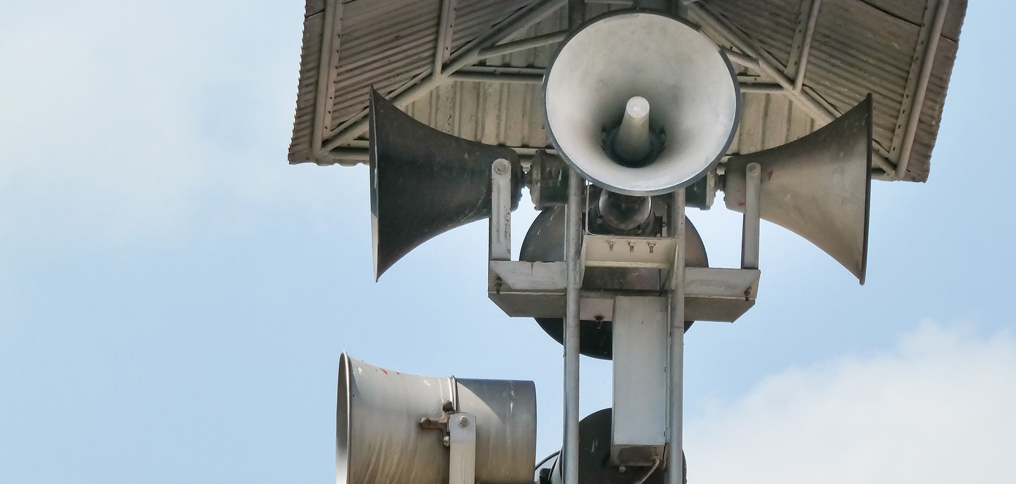 Vintage horn speaker tower with loudspeaker against the sky. Sys
