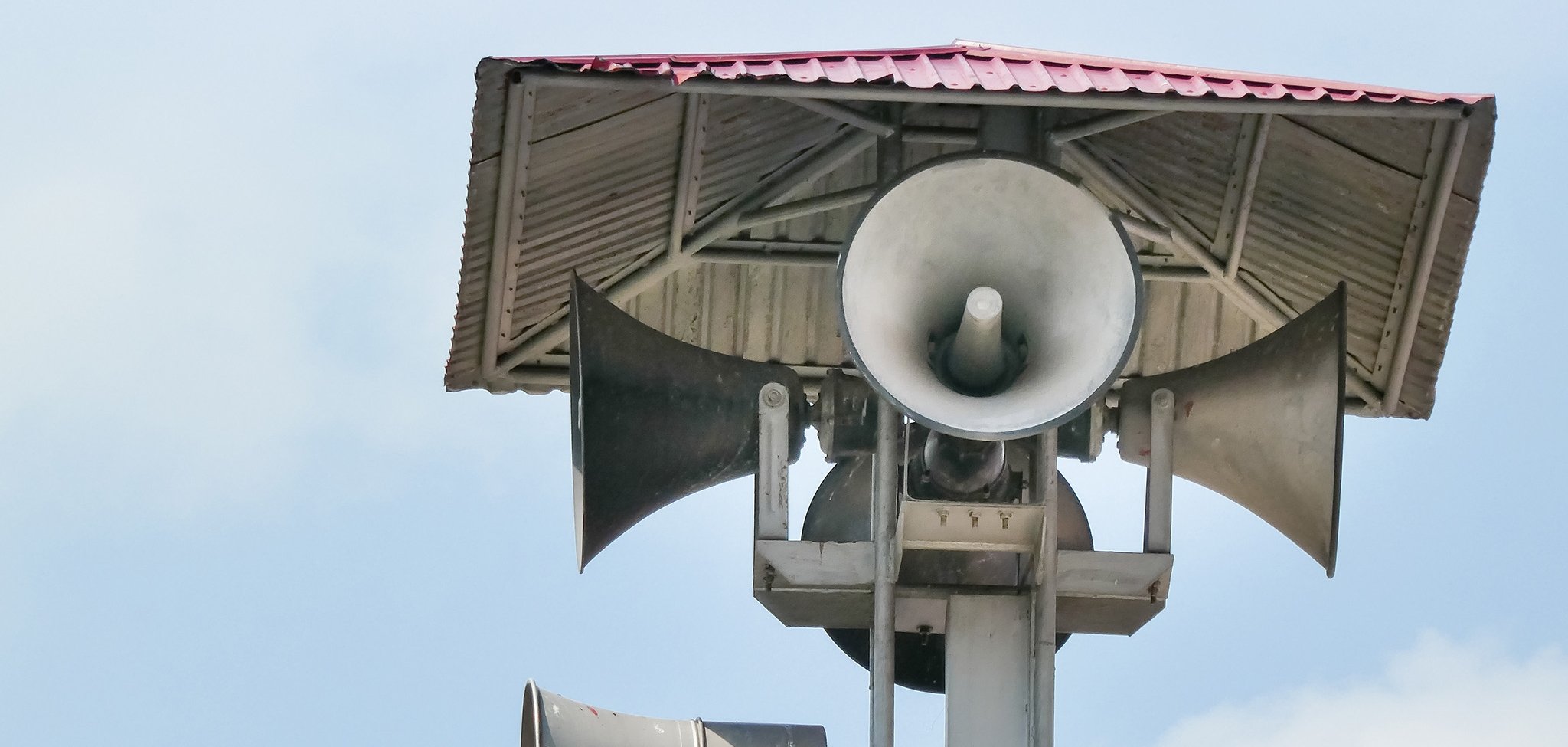 Vintage horn speaker tower with loudspeaker against the sky. Sys Vintage horn speaker tower with loudspeaker against the sky. Sys
