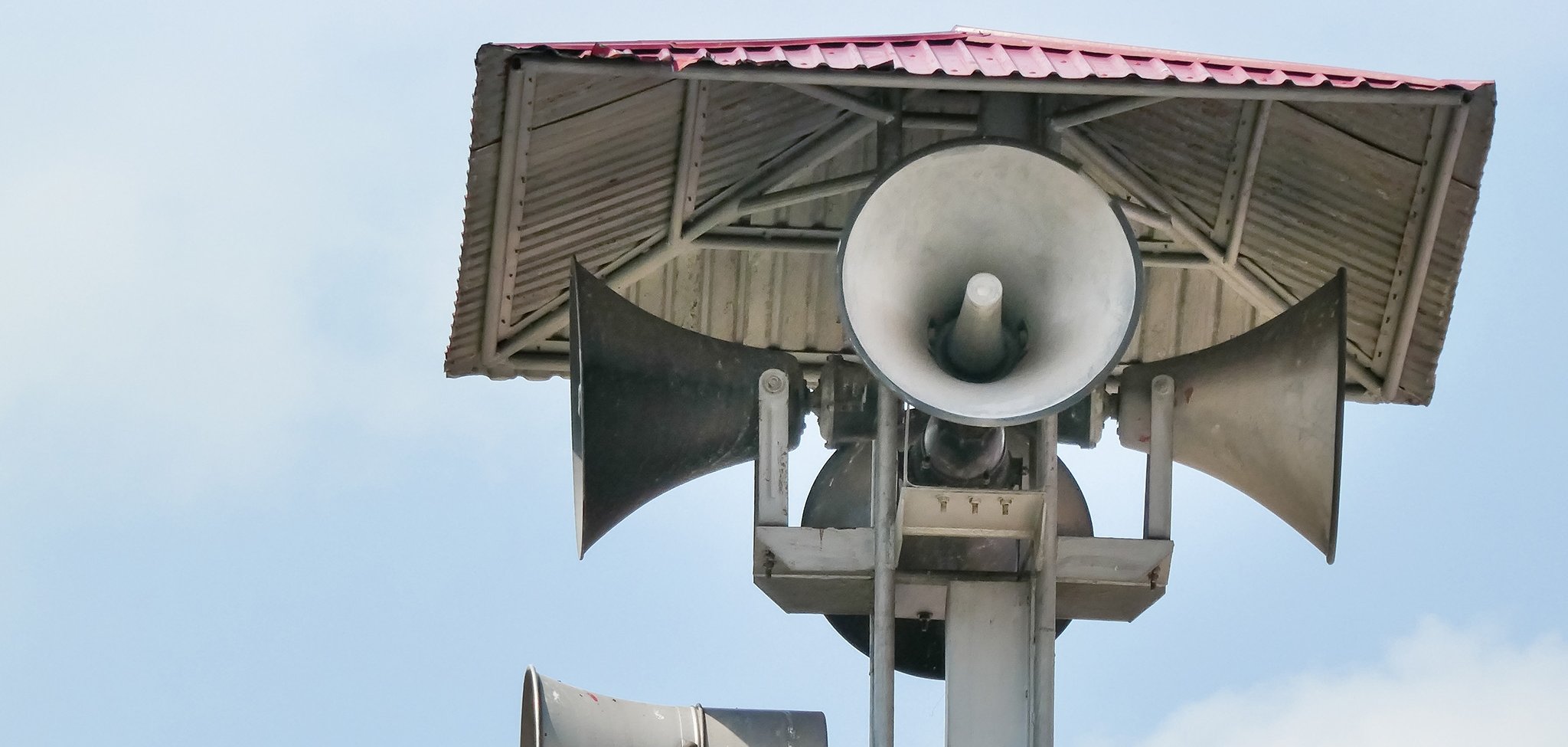Vintage horn speaker tower with loudspeaker against the sky. Sys Vintage horn speaker tower with loudspeaker against the sky. Sys