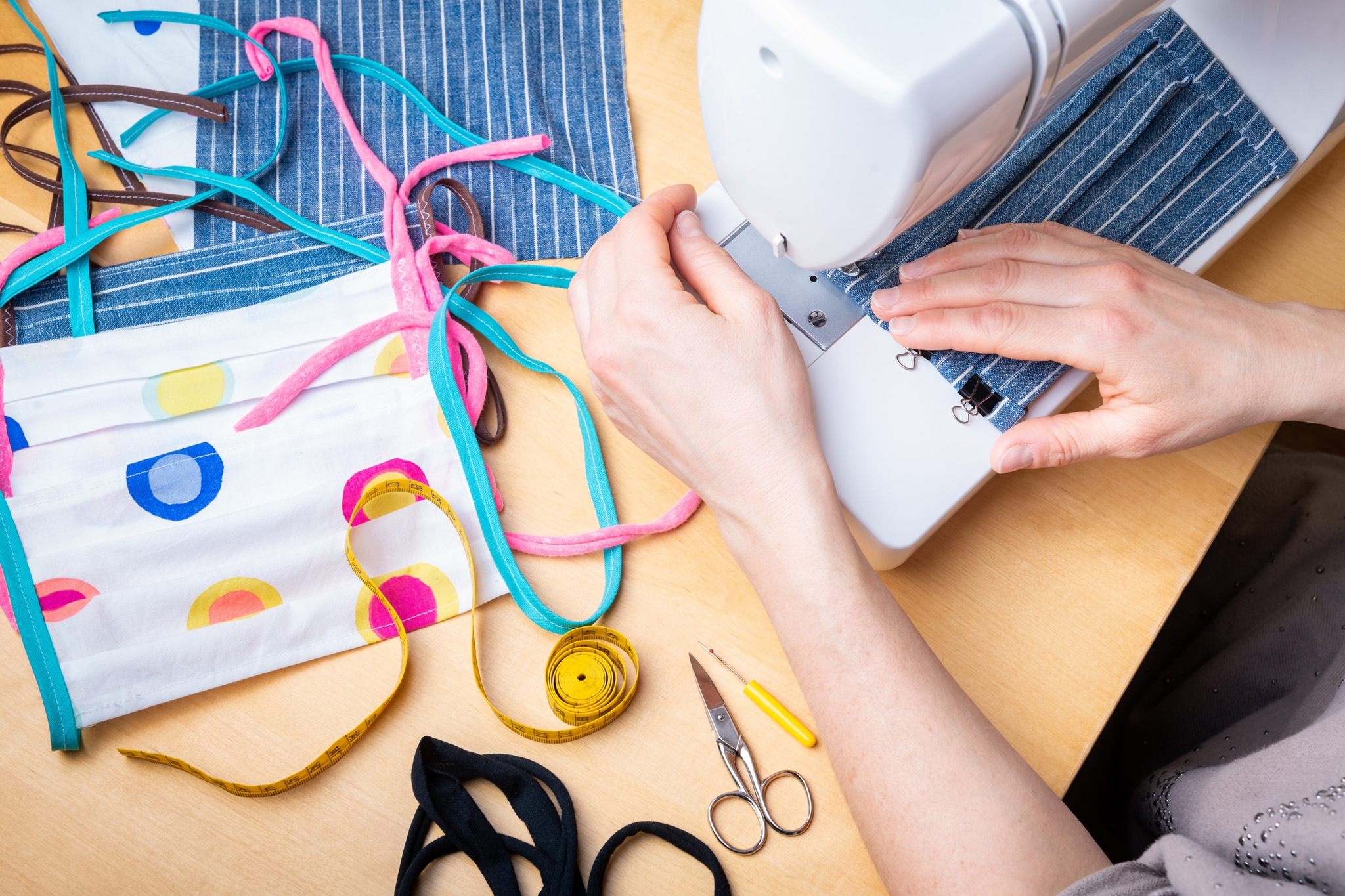Woman hands using the sewing machine to sew the face mask during