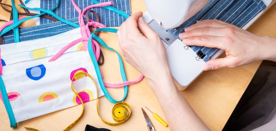 Woman hands using the sewing machine to sew the face mask during