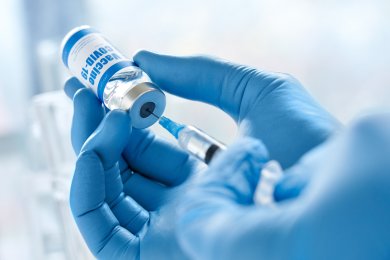 Male doctor hand wears glove holding syringe taking covid 19 vaccine from vial. Male doctor hand wears glove holding syringe taking covid 19 vaccine from vial.