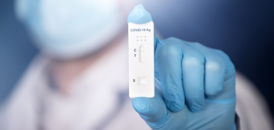 Medic hands in gloves holding negative COVID-19 test, rapid test