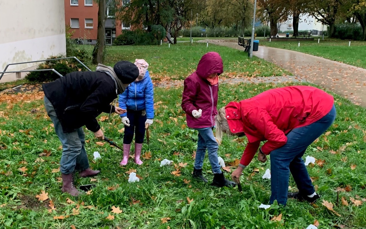 Kinder helfen kräftig mit beim Stecken von Blumenzwiebeln 