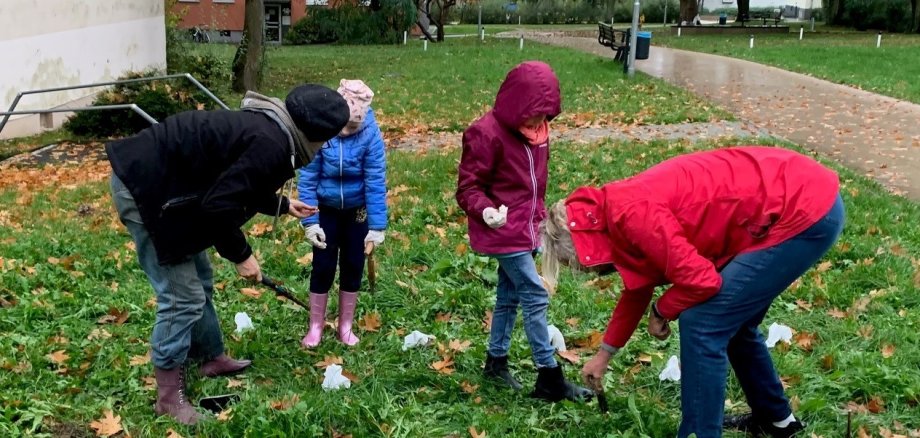 Kinder helfen kräftig mit beim Stecken von Blumenzwiebeln 