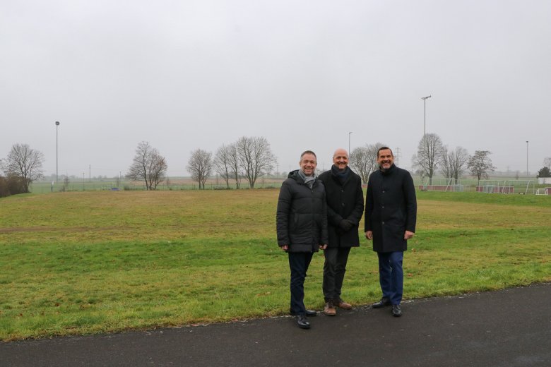 Ungenutzter Hartplatz unterhalb des Kunstrasenplatzes am Sportzentrum. Von links: Bürgermeister Steffen Bonk, Alexander Thomas, Geschäftsführer der PHORMS Schule und Erster Stadtrat Lars Knobloch